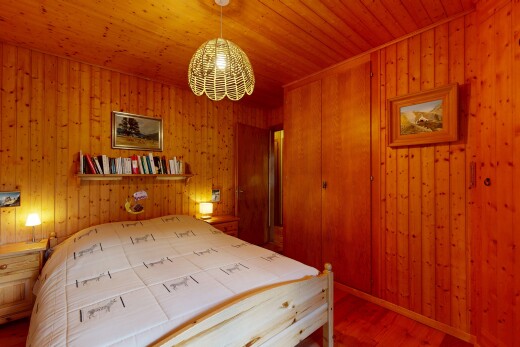 chambre avec inside property, mur en bois, wood wall, sol en finition bois, et wood finish floor