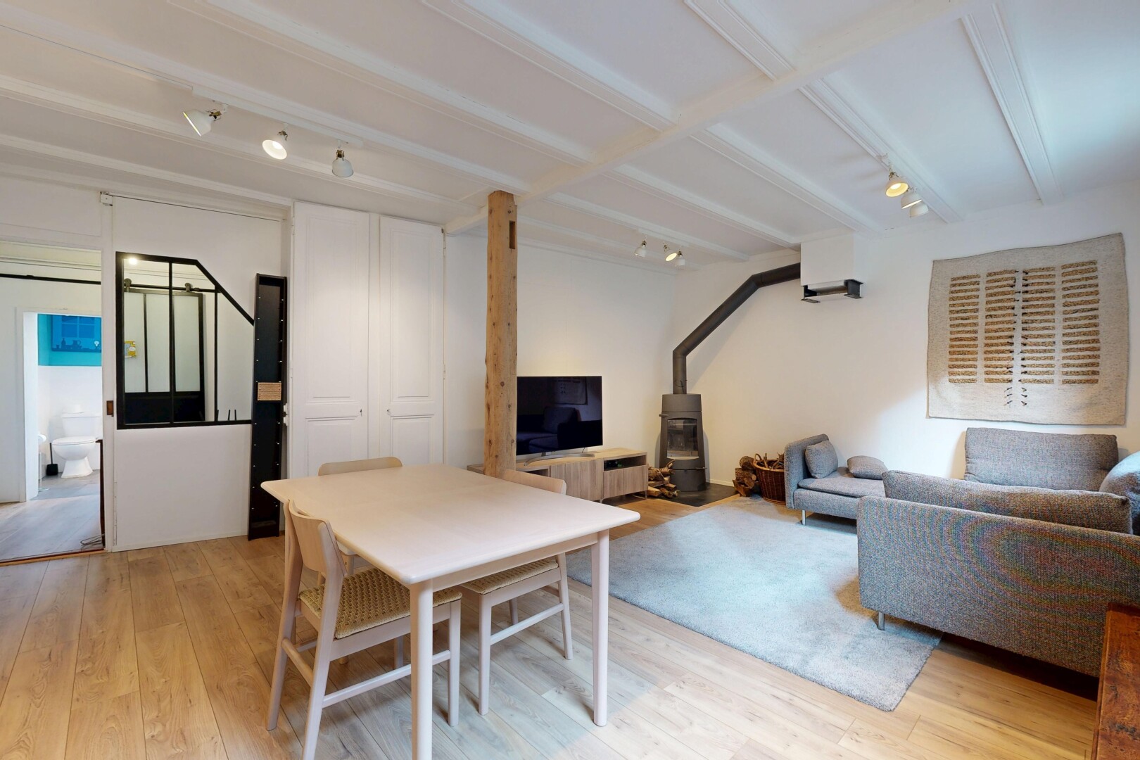 wohn- / esszimmer mit track lighting, deckenbeleuchtung, fernseher, wood finish floor, und holzfußboden