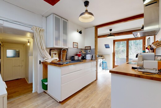cuisine avec armoires blanches, espace bureau, natural light, lumière naturelle, et wood finish floor