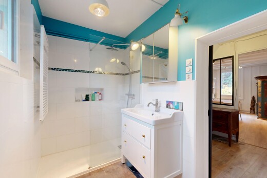 salle de bains avec natural light, lumière naturelle, miroir, lavabo (ou coiffeuse selon le contexte), et douche