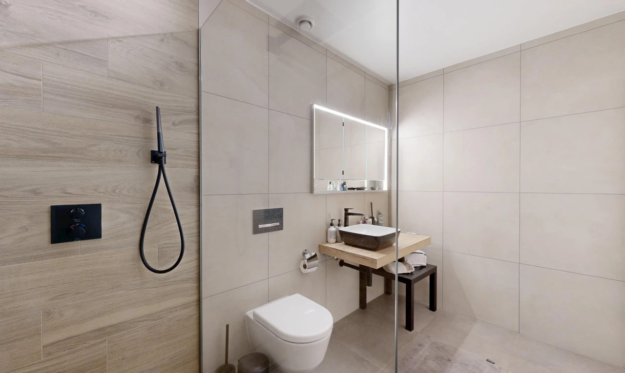 bathroom with tile walls, a walk in shower, and vanity