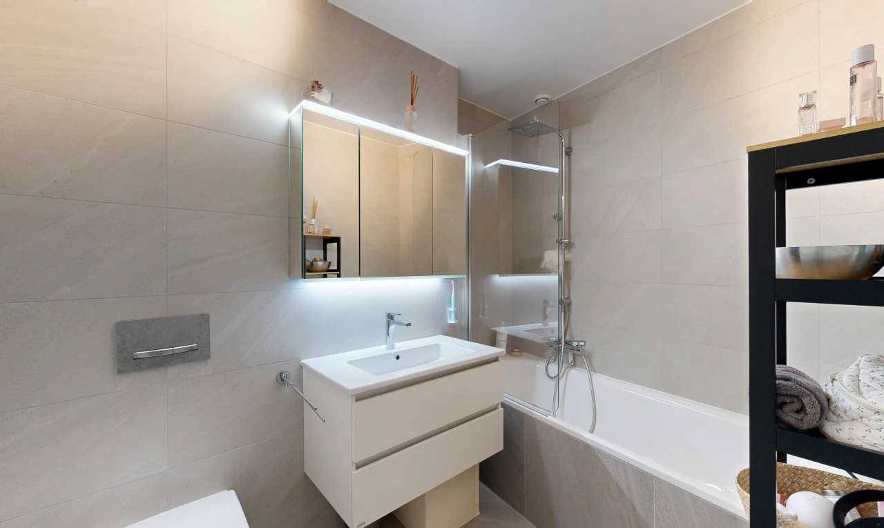 full bathroom featuring vanity, tiled shower / bath combo, and tile walls