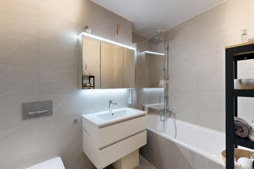 full bathroom featuring vanity, tiled shower / bath combo, and tile walls