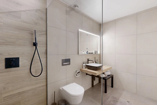 bathroom with tile walls, a walk in shower, and vanity
