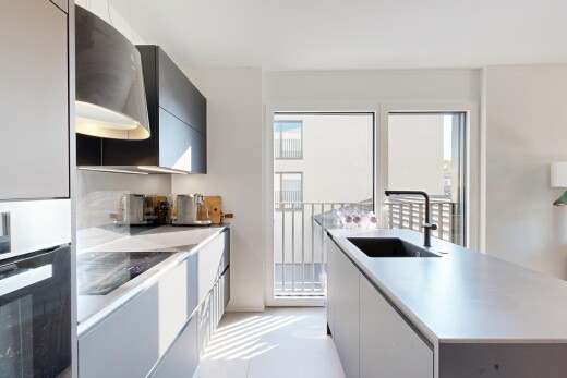 cuisine avec four, évier, plans de travail, light countertops, et kitchen island sink