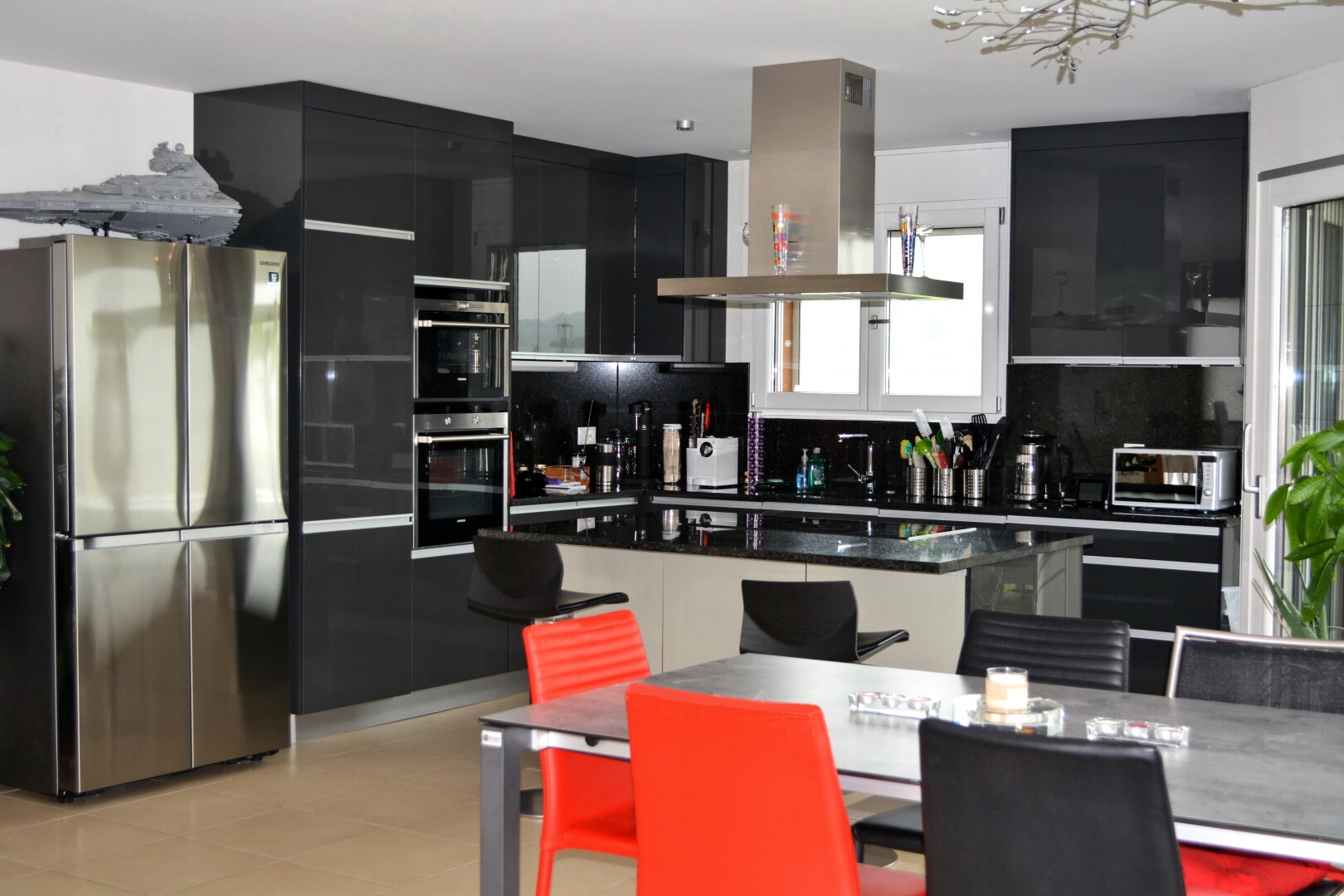 küche mit kühlschrank, dunstabzugshaube, kücheninsel, kitchen island, und schwarze schränke