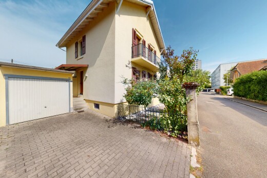 façade avec day time, bardage en stuc, allée, garage, et property visible