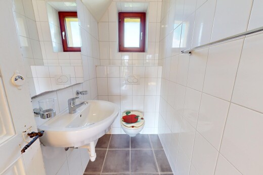 salle de bains avec toilette, tile wall, mur en carrelage, natural light, et lumière naturelle