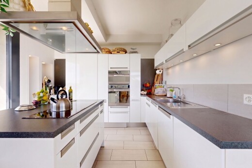 cuisine avec dark countertops, plans de travail, white cabinets, armoires blanches, et hotte