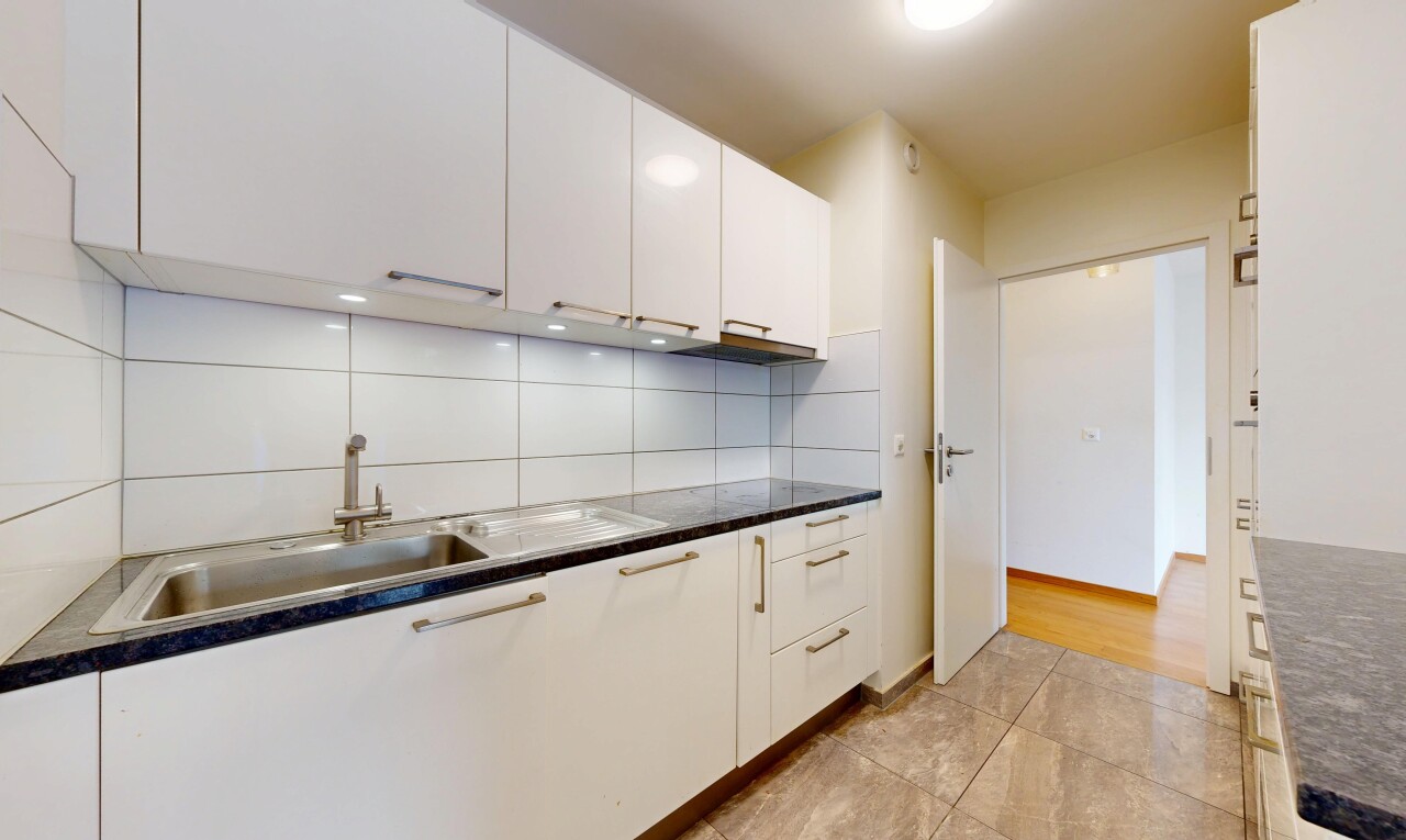 cuisine avec white cabinets, armoires blanches, dark countertops, plans de travail, et light floor