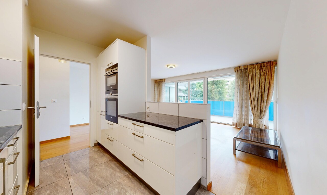 cuisine avec white cabinets, armoires blanches, light floor, dark countertops, et plans de travail
