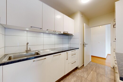 kitchen with white cabinets, dark countertops, backsplash, and light tile patterned floors