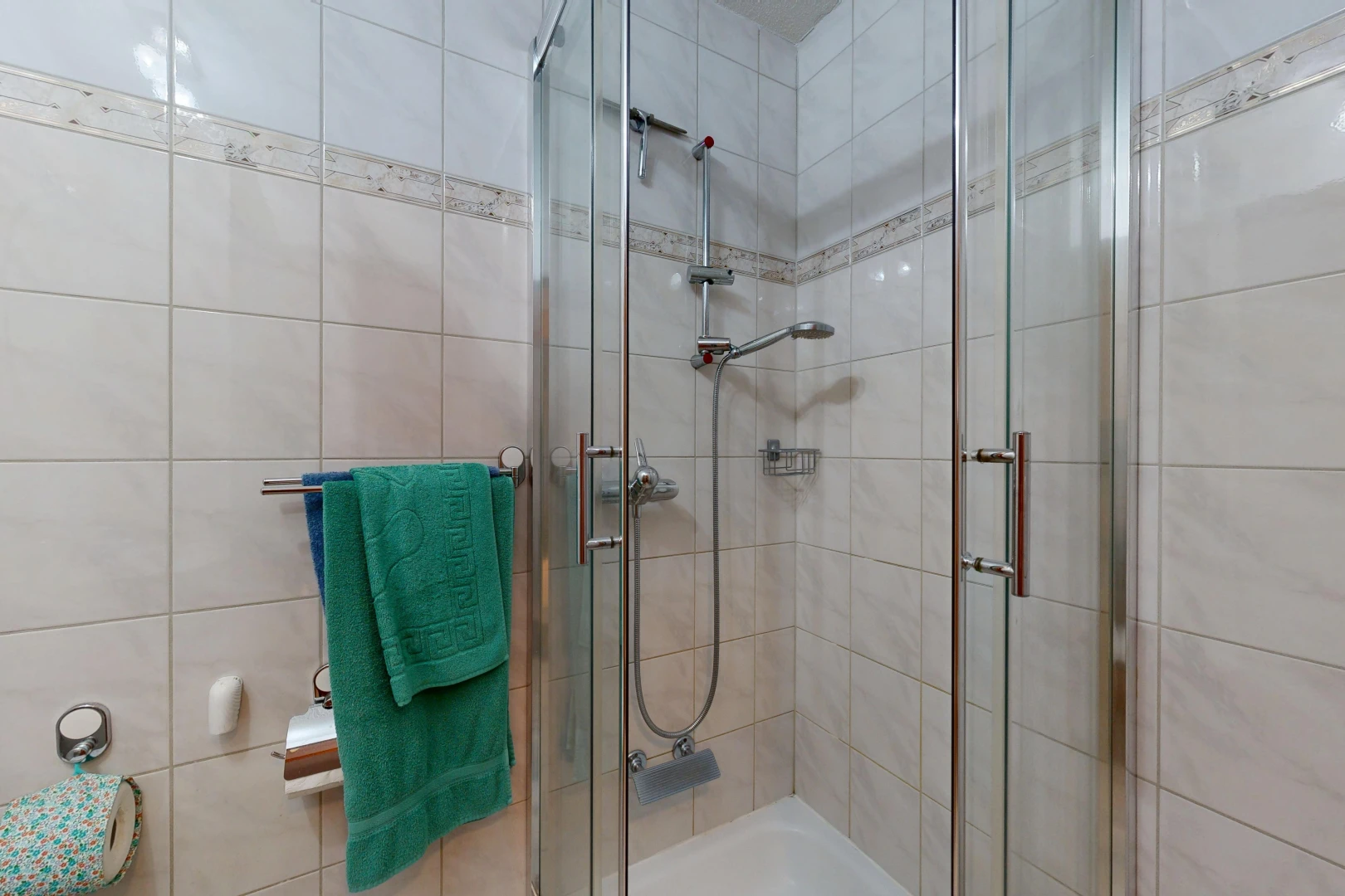 full bath featuring a shower stall and tile walls