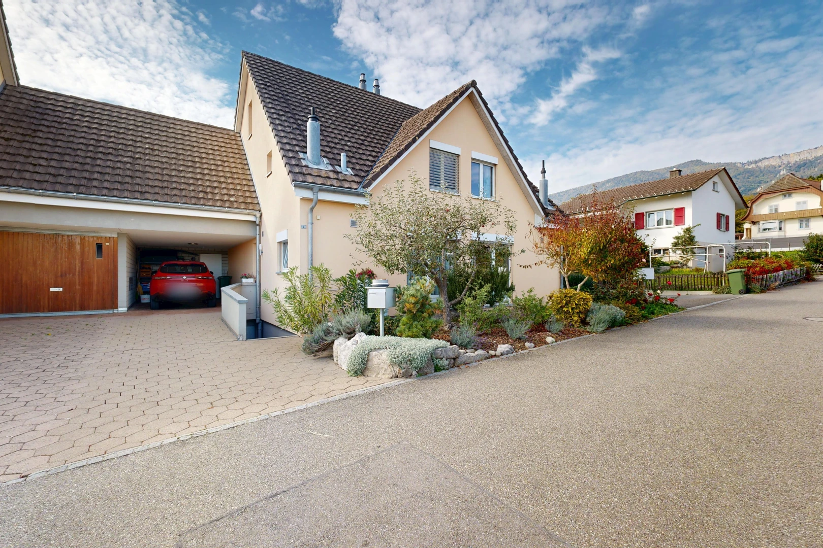 view of home with driveway, stucco siding, a tiled roof, and a residential view