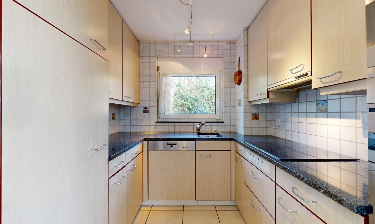kitchen with backsplash, light tile patterned floors, dishwasher, dark stone countertops, and light wood finish cabinetry