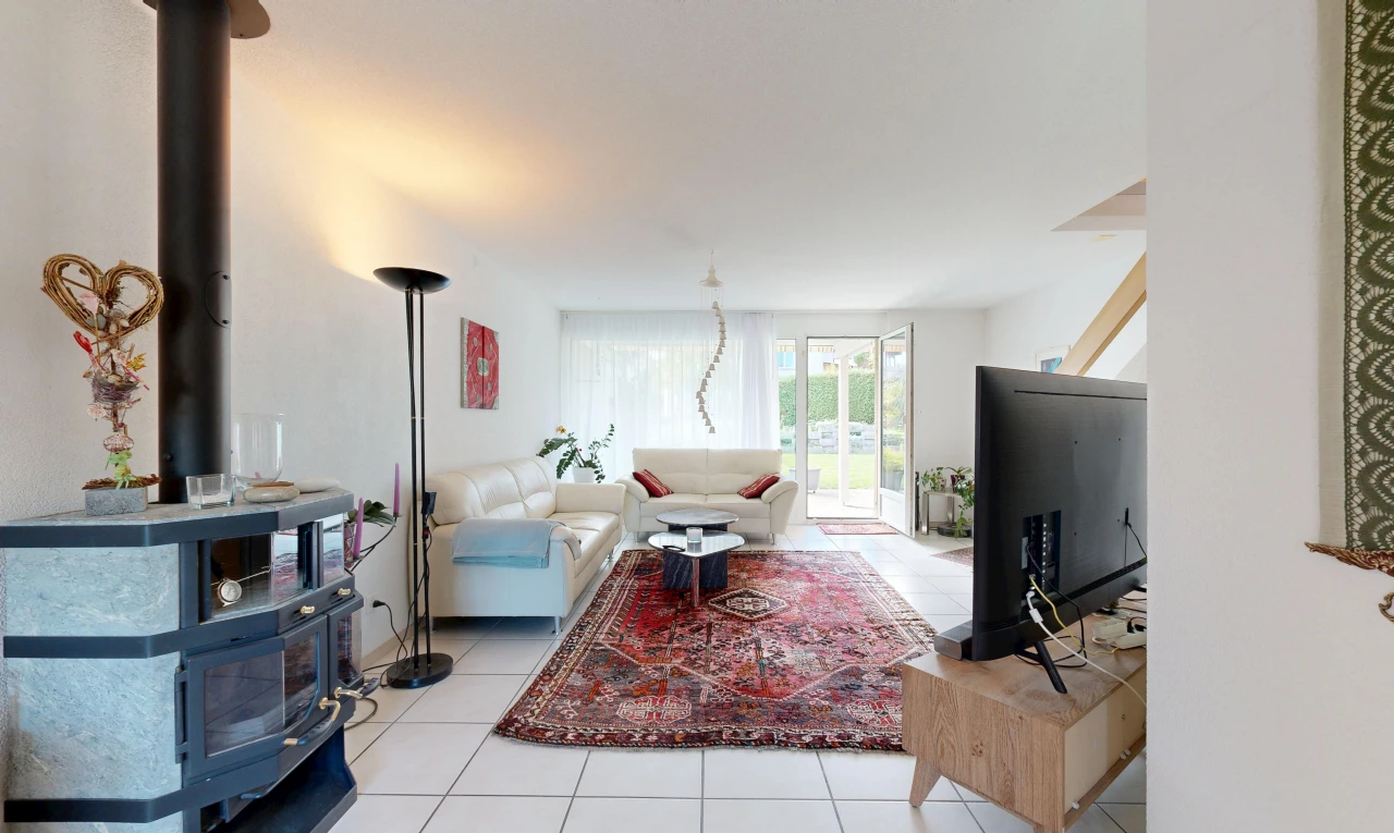 living area with a wood stove, light tile patterned floors, and access to exterior