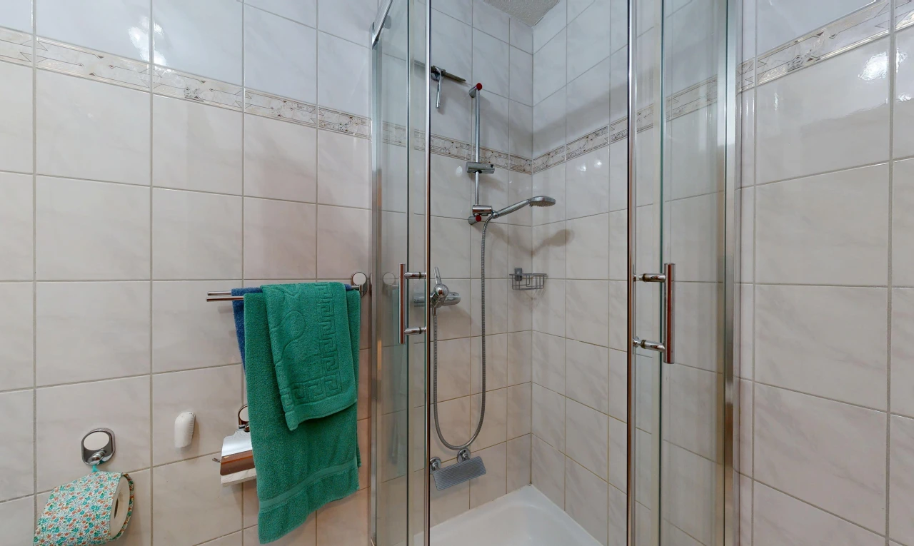 full bath featuring a shower stall and tile walls
