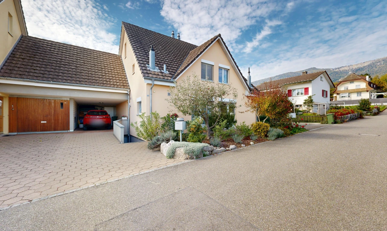 view of home with driveway, stucco siding, a tiled roof, and a residential view
