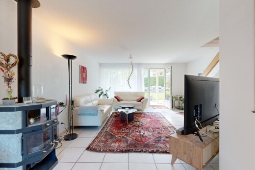 living area with a wood stove, light tile patterned floors, and access to exterior