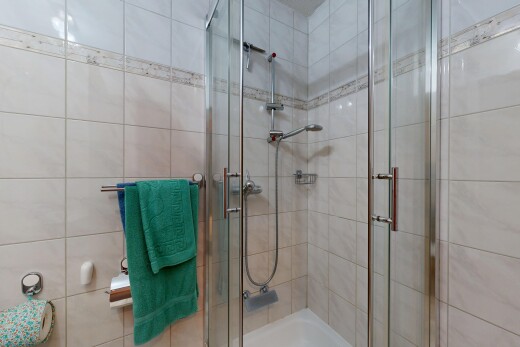 full bath featuring a shower stall and tile walls