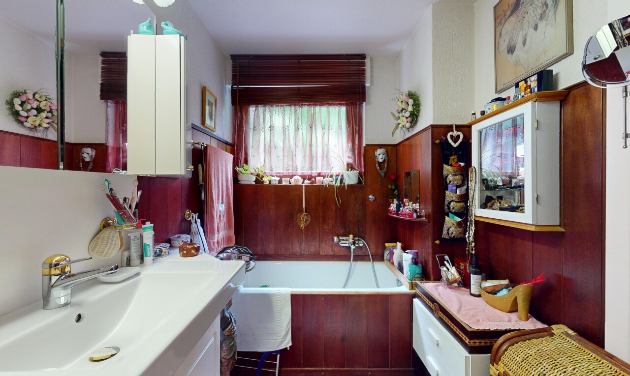 full bathroom featuring vanity, a bath, and wooden walls