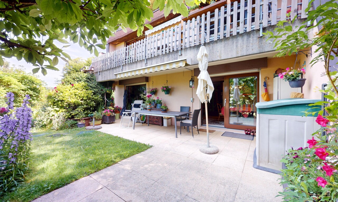 view of property featuring a balcony, a patio, stucco siding, and a lawn