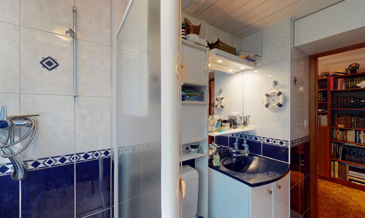 full bath with tile walls, vanity, tiled shower, tile patterned flooring, and tasteful backsplash