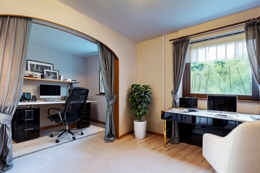 office area with arched walkways and wood finished floors