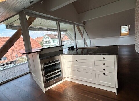 küche mit weiße schränke, wood finish floor, holzfußboden, schranktüren mit vertiefter mittelplatte, und natural light