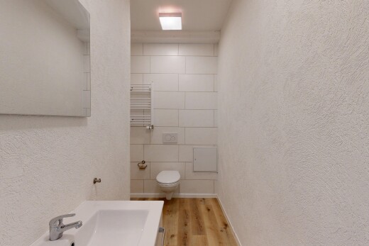 salle de bains avec textured wall, mur texturé, chauffe-serviettes, wood finish floor, et sol en finition bois
