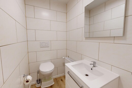 salle de bains avec toilette, tile wall, mur en carrelage, lavabo (ou coiffeuse selon le contexte), et inside property