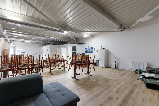 wohn- / esszimmer mit inside community, wood finish floor, holzfußboden, kühler, und drywall