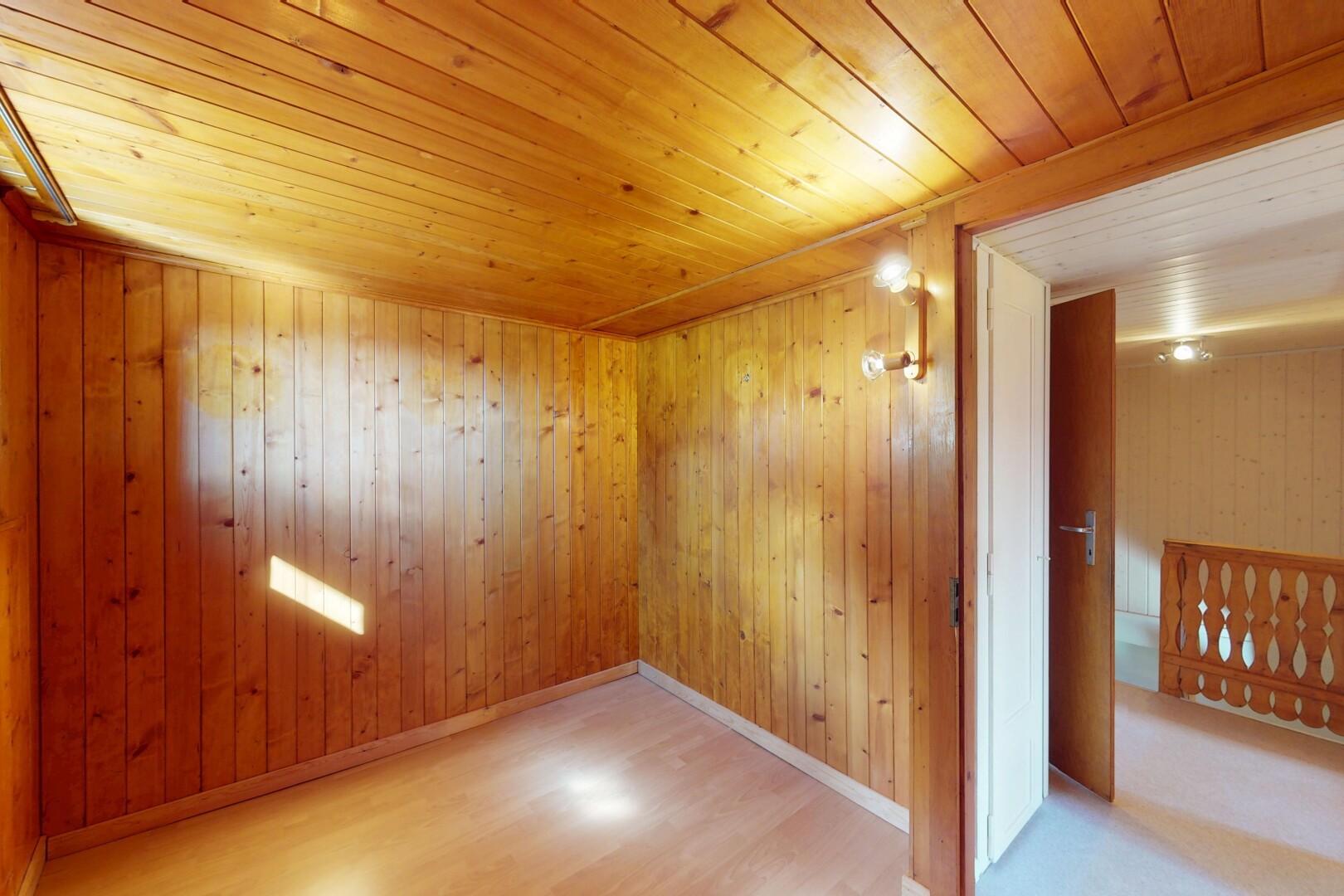 pièce vide avec sol en finition bois, plafond en bois, plinthes murales, et plafond bas