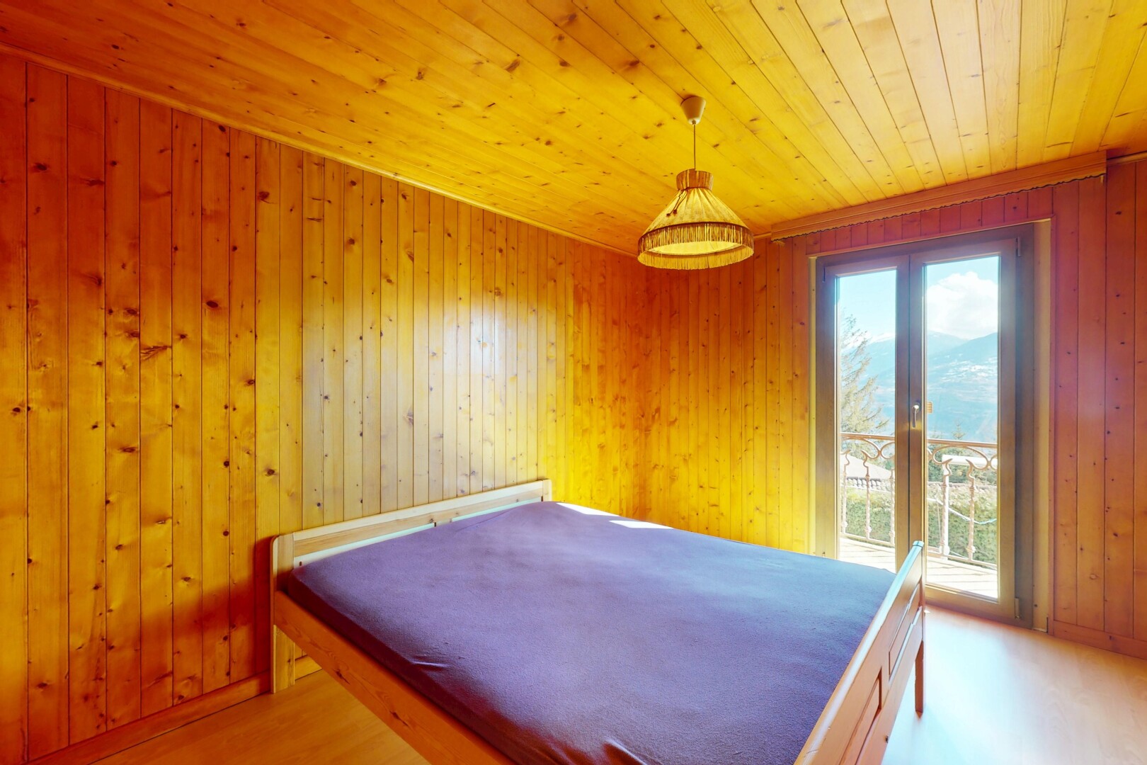 chambre avec plafond en bois, lumière naturelle, et mur en bois