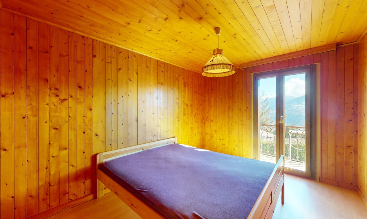 chambre avec plafond en bois, lumière naturelle, et mur en bois