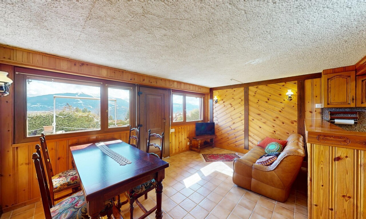 salon / salle à manger avec mur en bois, plafond texturé, et lumière naturelle