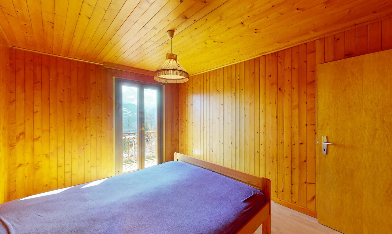 chambre avec mur en bois, plafond en bois, et lumière naturelle