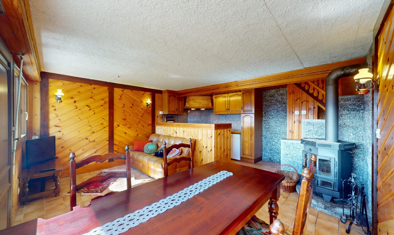 salle à manger avec plafond texturé et poêle à bois
