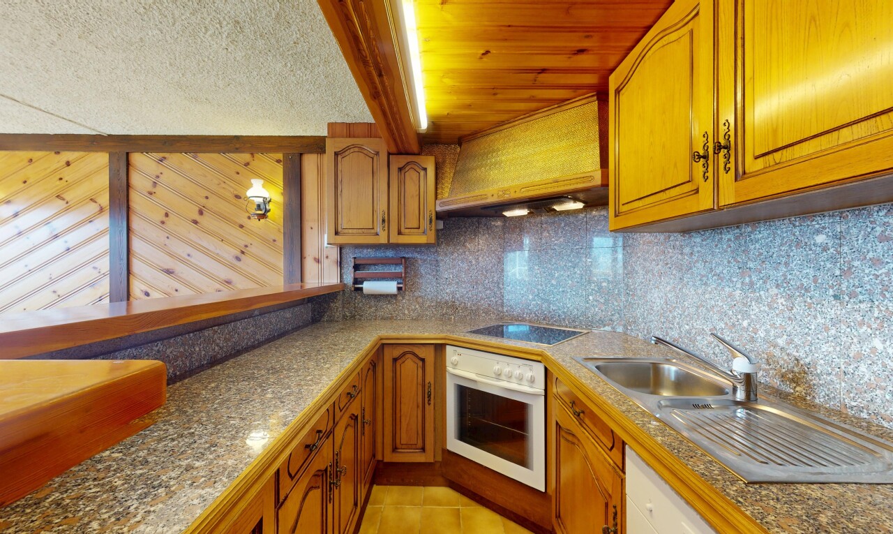 cuisine avec armoires en arc, dosseret, four, plaque de cuisson, et sol en carrelage
