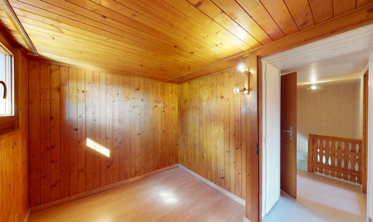 pièce vide avec sol en finition bois, plafond en bois, plinthes murales, et plafond bas