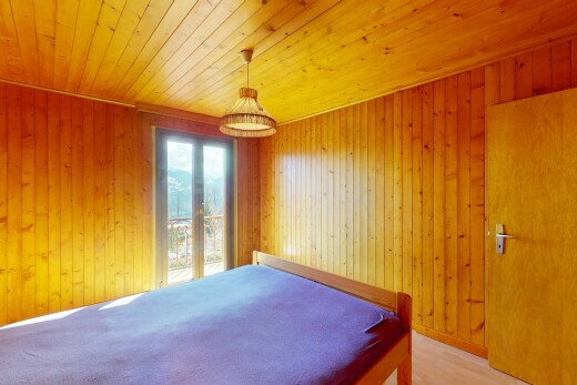 chambre avec mur en bois, plafond en bois, et lumière naturelle