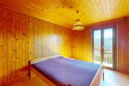 chambre avec plafond en bois, lumière naturelle, et mur en bois
