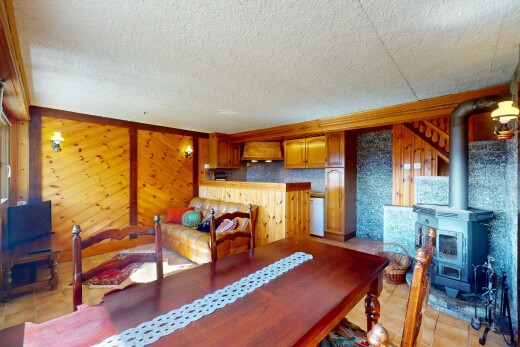 salle à manger avec plafond texturé et poêle à bois