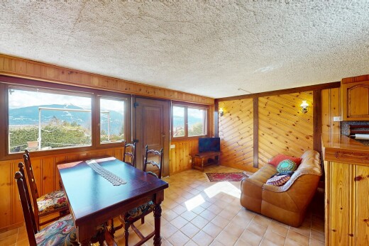 salon / salle à manger avec mur en bois, plafond texturé, et lumière naturelle