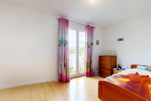 chambre avec wood finish floor, sol en finition bois, drywall, cloison sèche, et natural light