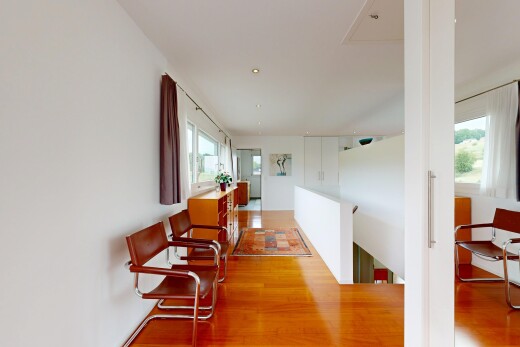 couloir avec inside property, cloison sèche, drywall, sol en finition bois, et wood finish floor