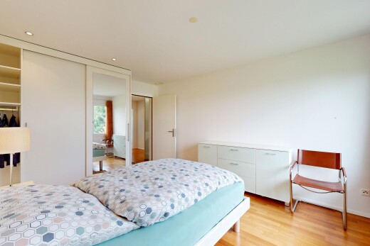 chambre avec placard, sol en finition bois, wood finish floor, inside property, et light floor