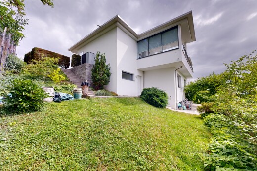 façade avec overcast, property visible, bardage en stuc, pelouse, et terrasse