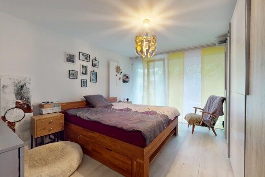 zimmer / schlafzimmer mit inside property, bemerkenswerter kronleuchter, natürliches licht, natural light, und holzfußboden