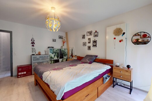 zimmer / schlafzimmer mit bemerkenswerter kronleuchter, gipskartonwand, drywall, inside property, und holzfußboden